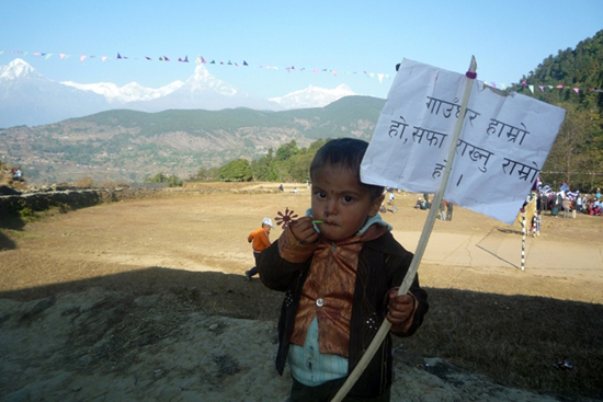 प्ले-कार्ड बोकेर र्‍यालीमा सहभागि एक बालक