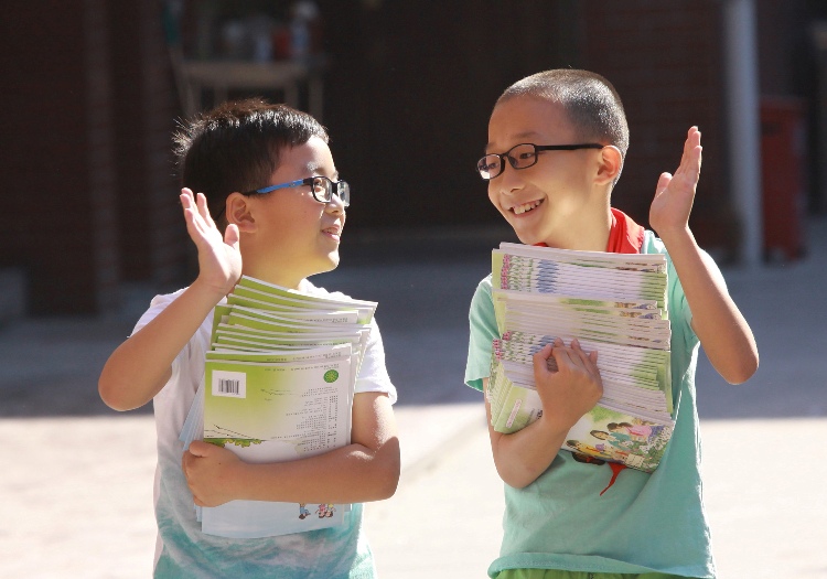 (160902) -- WUXI, Sept. 2, 2016 (Xinhua) -- Two boys clap hands as getting new textbooks at a primary school in Wuxi City, east China's Jiangsu Province, Aug. 31, 2016. Local schools have reopened after summer vacation. (Xinhua/Tang Yi) (ry)